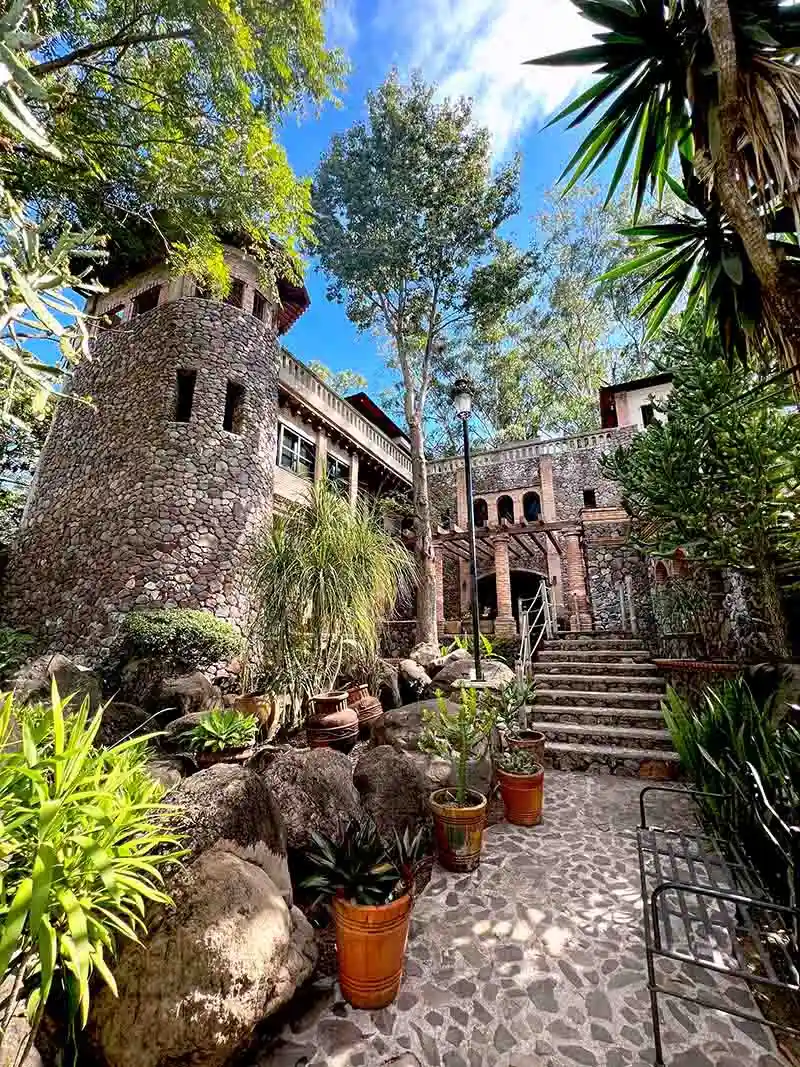 Área de Quinta Pichón presenta naturaleza entre árboles y jardineras, su arquitectura rústica está hecha de mampostería.