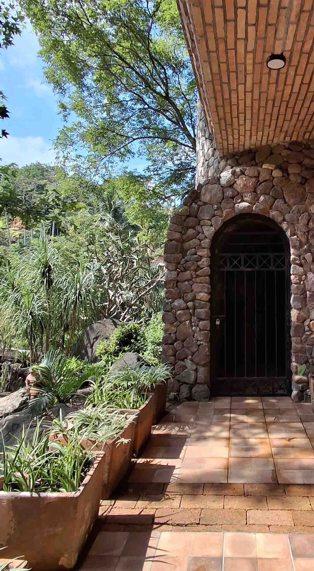 Área de Quinta Pichón, donde se encuentra una entrada con un estilo rústico y los muros construidos de mampostería rodeados de naturaleza.