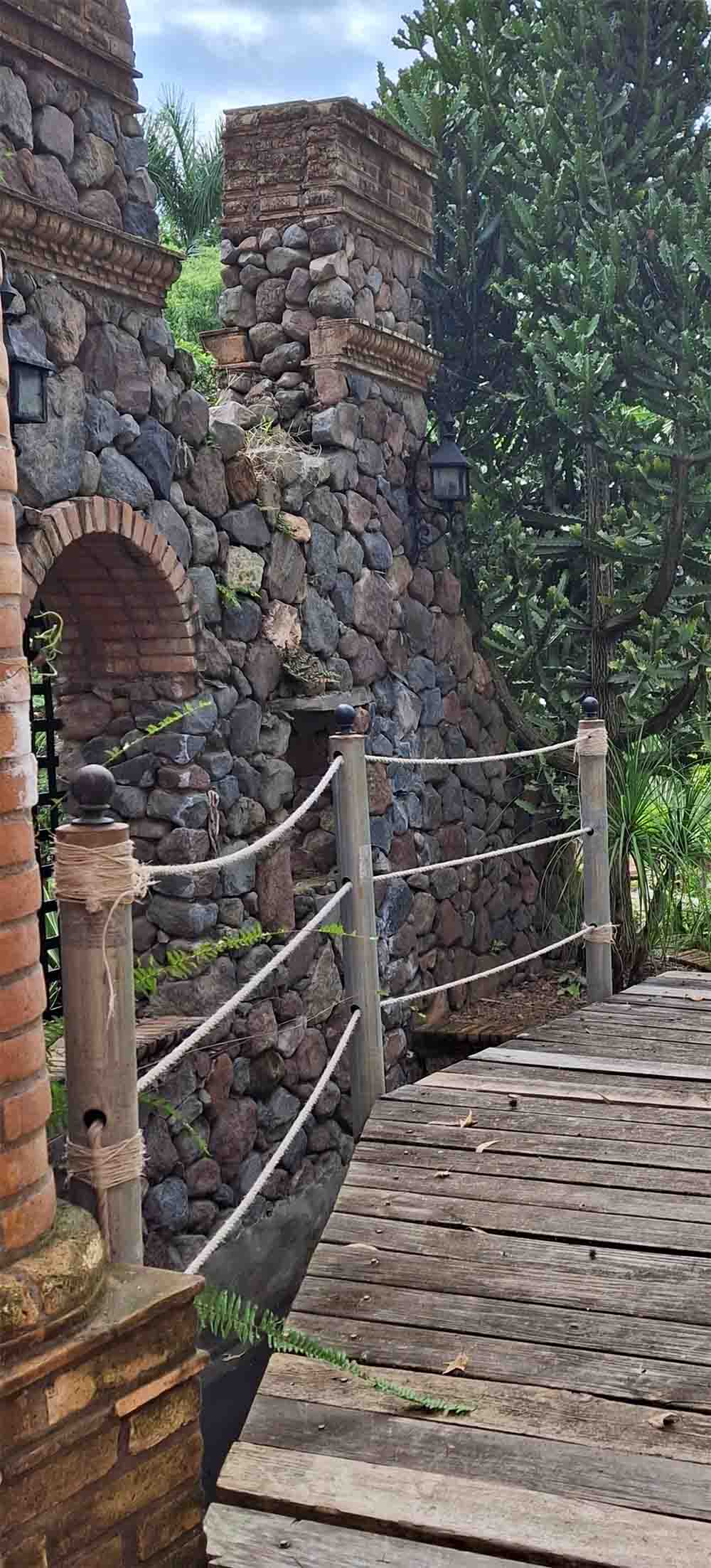 Área de Quinta Pichón donde se encuentra un puente de madera con un muro construido de mampostería rodeado de naturaleza.
