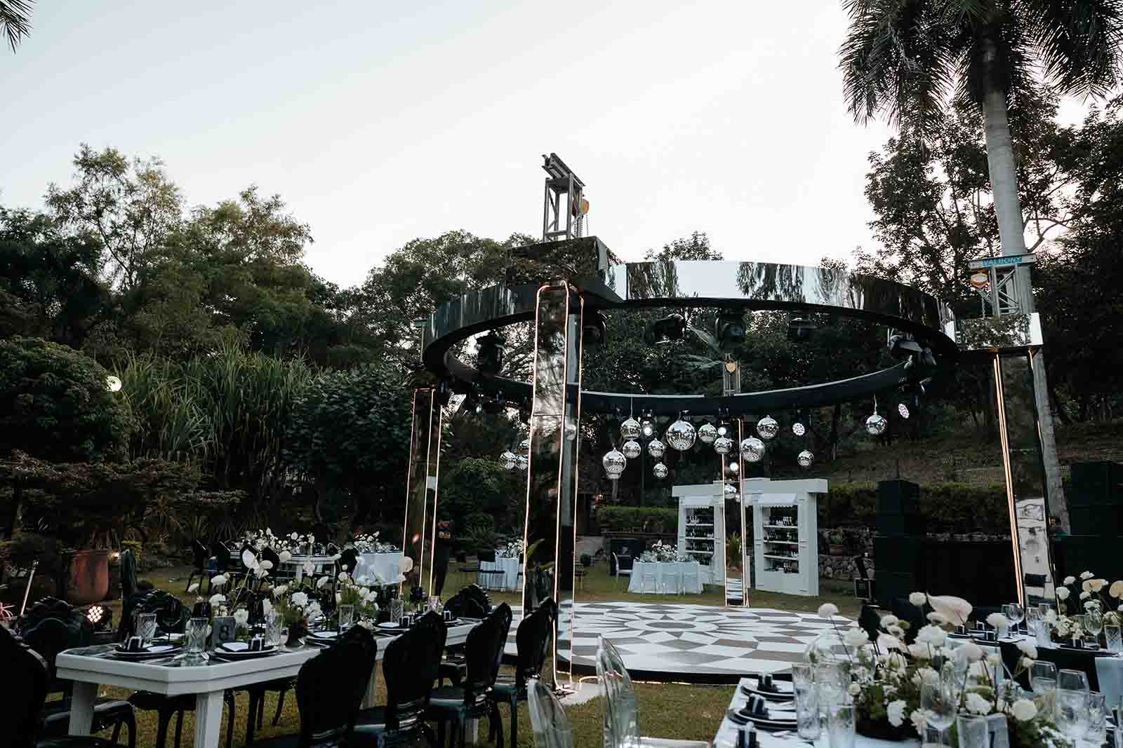 Jardín de quinta Pichón en Tepic, Nayarit, donde se celebra un evento social con un escenario en el centro y decoración elegante con colores blancos y negros.