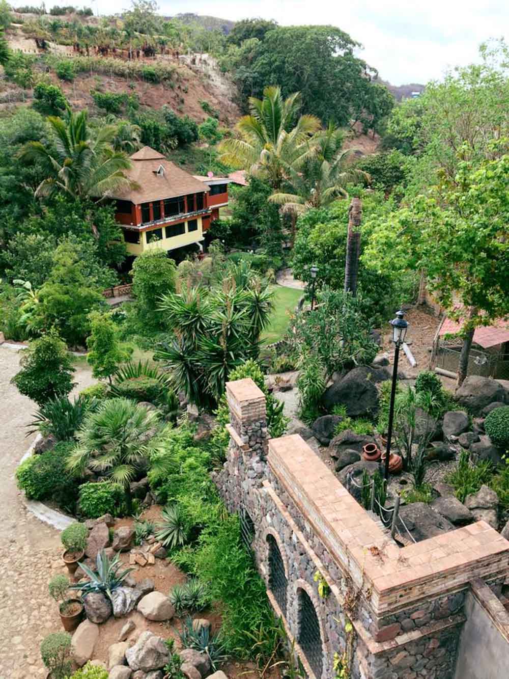 Entrada de Quinta Pichón rodeada de naturaleza, de arquitectura tradicional, con algunas edificaciones hechas de mampostería.