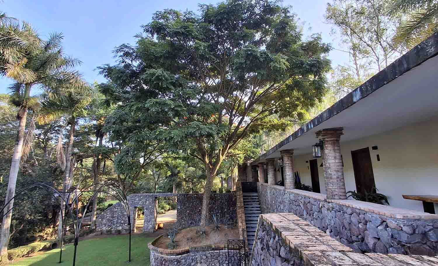 Fachada de la zona de hospedaje de Quinta Pichón con un estilo rústico tradicional con acabados en mampostería, con un gran jardín y rodeado de naturaleza.