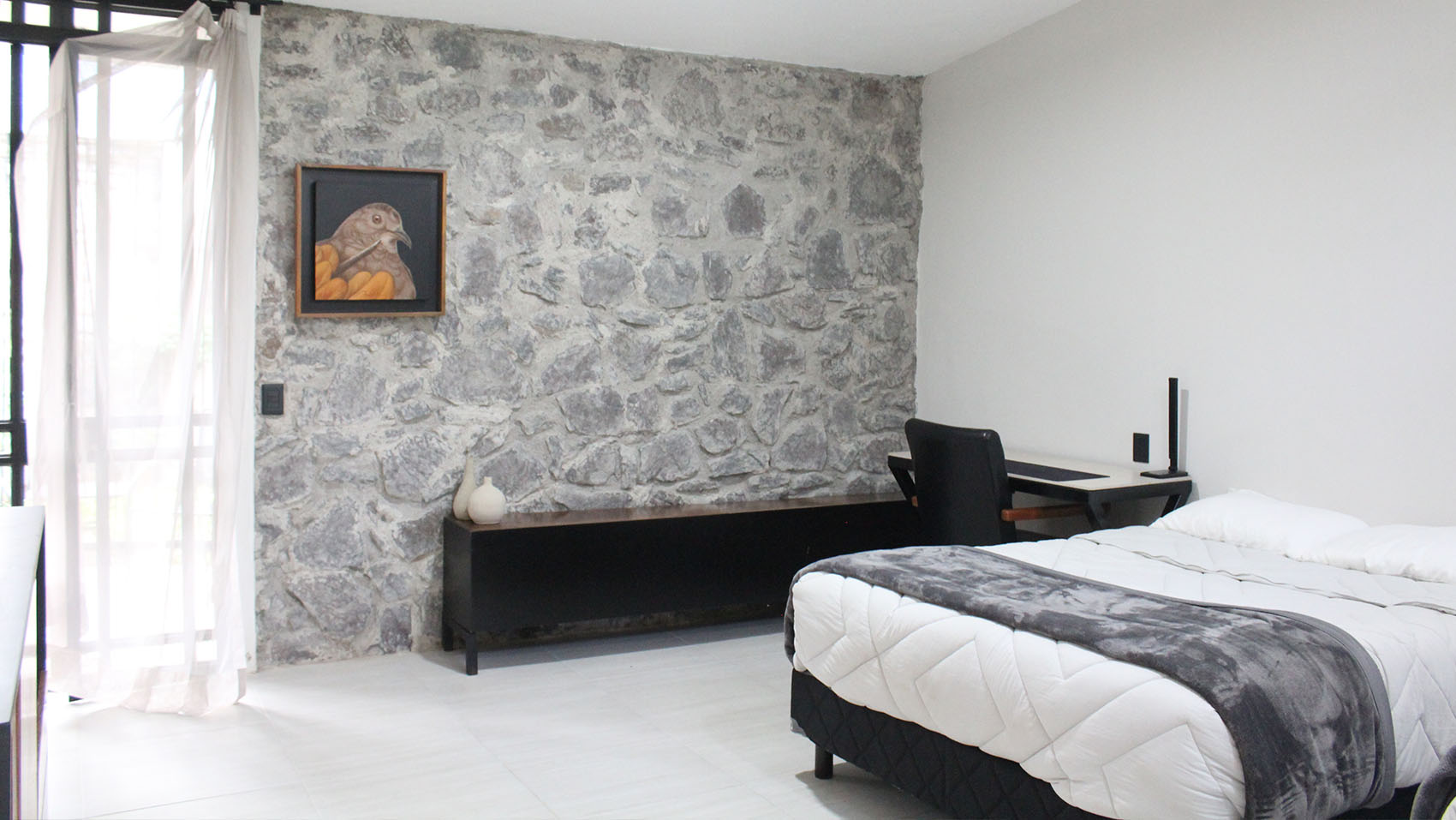 Habitación de la hotelería Quinta Pichón, estilo tradicional con acabados de mampostería en algunas paredes y muebles modernos.