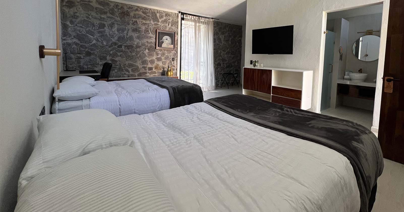 Habitación de la zona para huéspedes de Quinta Pichón, su interior cuenta con dos camas, muebles y servicios necesarios para una estadía cómoda.