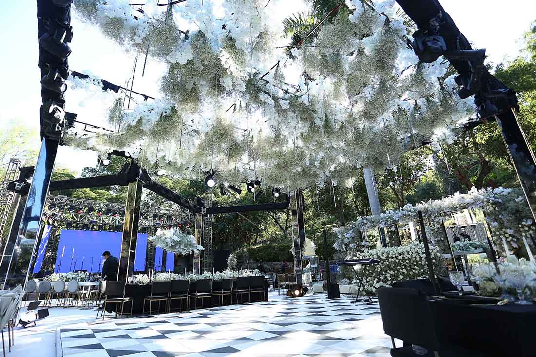 Gran escenario en tonos blanco y negro, instalado en un jardín de Quinta Pichón para la celebración de una boda.