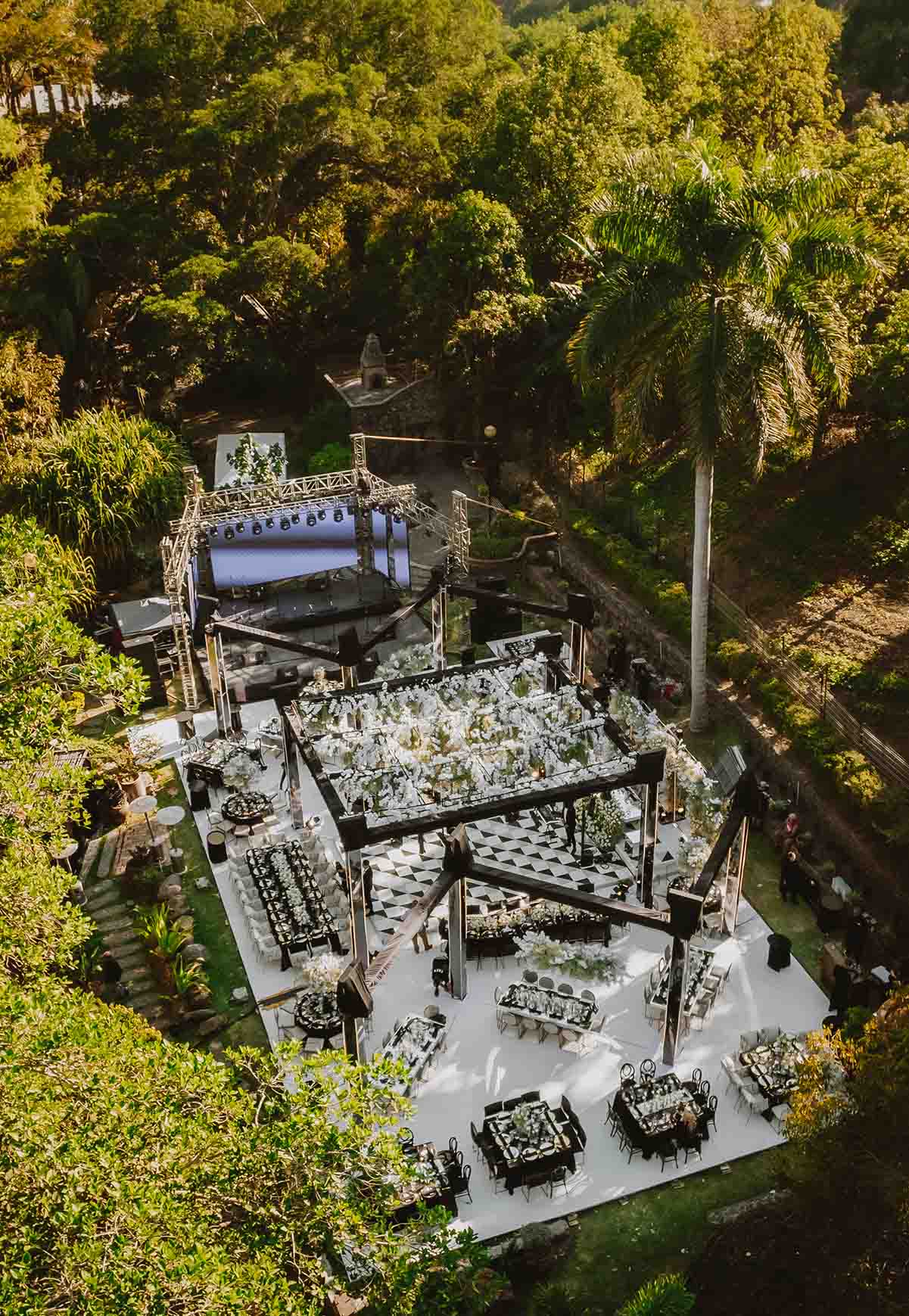 Jardín principal de Quinta Pichón rodeado de arboles con un gran escenario para un evento.