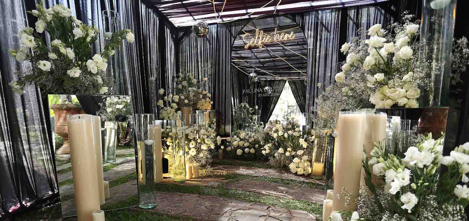 Zona dentro de Quinta Pichón decorada con flores, velas y adornos de color blanco para llevar acabo un evento social.