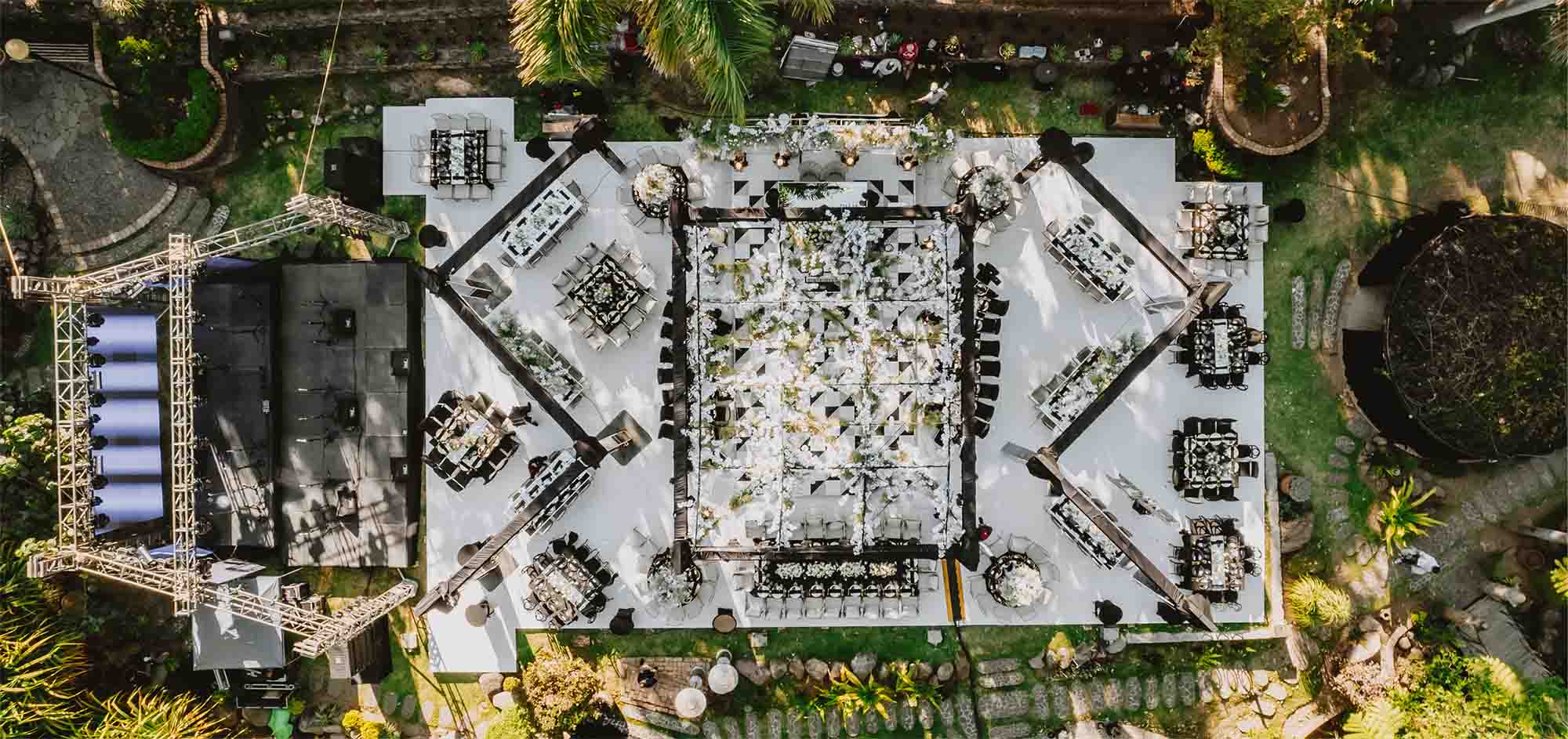 Jardín principal de Quinta Pichón rodeado de arboles con un gran escenario color blanco para un evento.