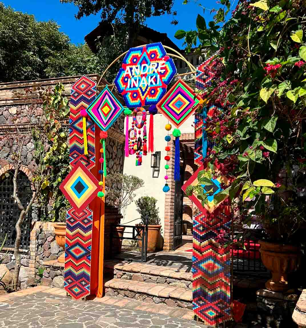 Fachada de la entrada para la Casona en Quinta Pichón, la fachada tiene un acabado rustico con piedras en el diseño arquitectónico, en esta entrada hay un arco artesanal estilo huichol para decorar.