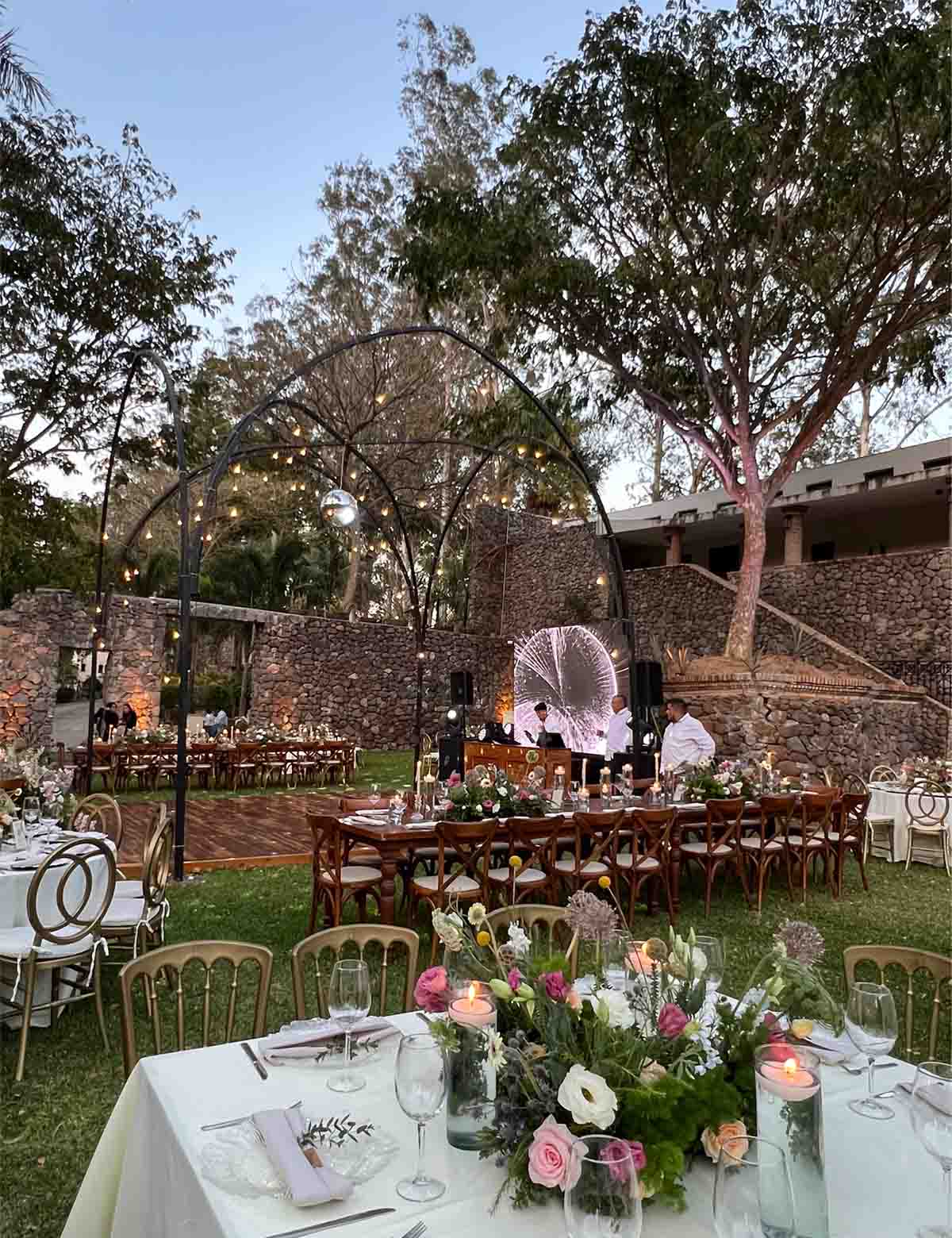 Jardín de Quinta Pichón con mobiliario y adornos para celebrar un evento social con un gran arco metálico en el centro decorado para el evento.