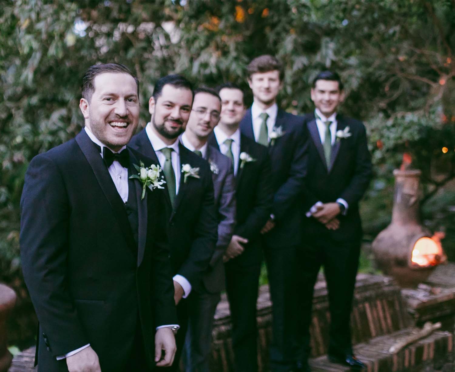 Novio acompañado de sus caballeros de honor; todos visten trajes de color negro muy elegantes.