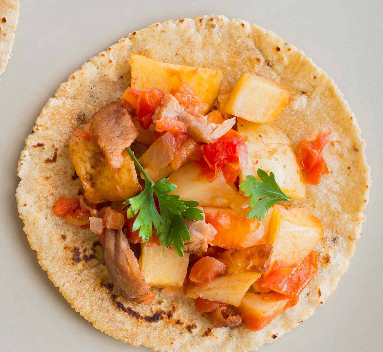 Pescado cocinado con vegetales servido en torrtilla de maíz.