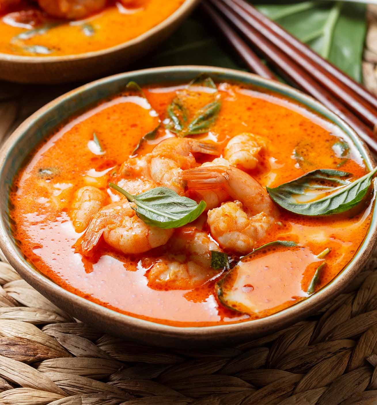 Pozole de camarón con maíz servido con algunas hojas de albahaca para decorar.