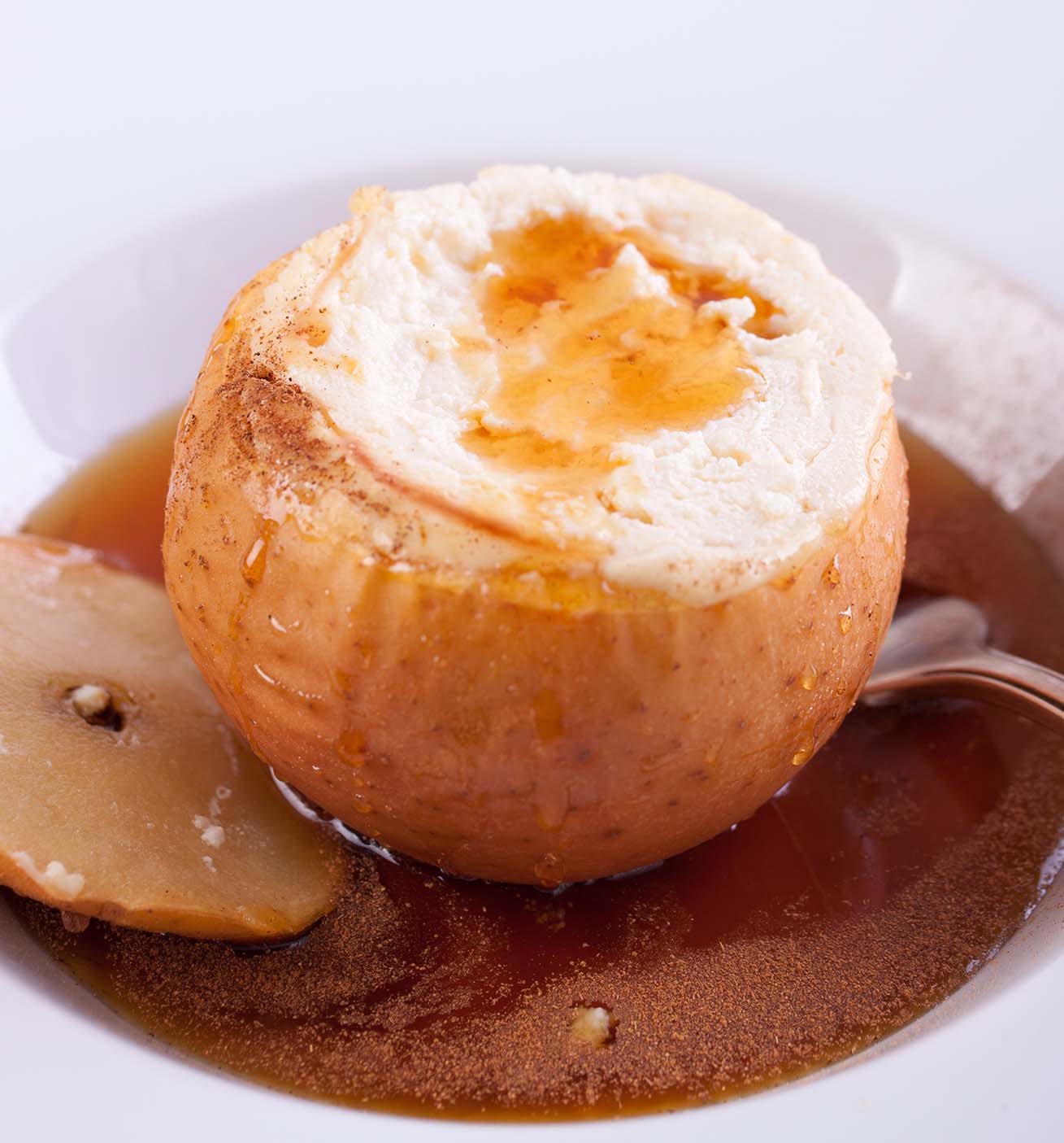 Helado de vainilla con pudín de manzana servido dentro de la cáscara de una manzana.