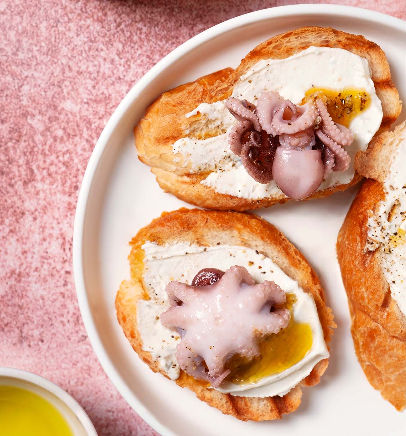 Pulpo a la parrilla con salsa, queso y pan.