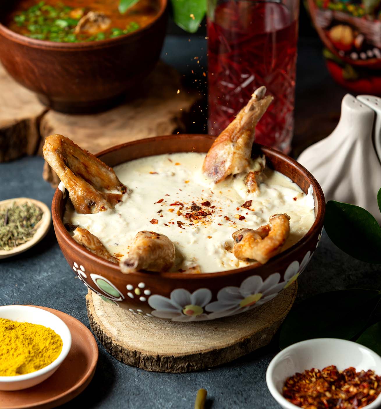 Platillo hecho con partes de codorniz en salsa y chile seco quebrado, servido en un plato de barro tradicional.