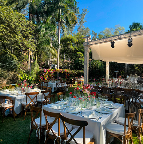 Evento social celebrado en un jardín de Quita Pichón, la decoración tiene colores rojos, rosas y blanco.