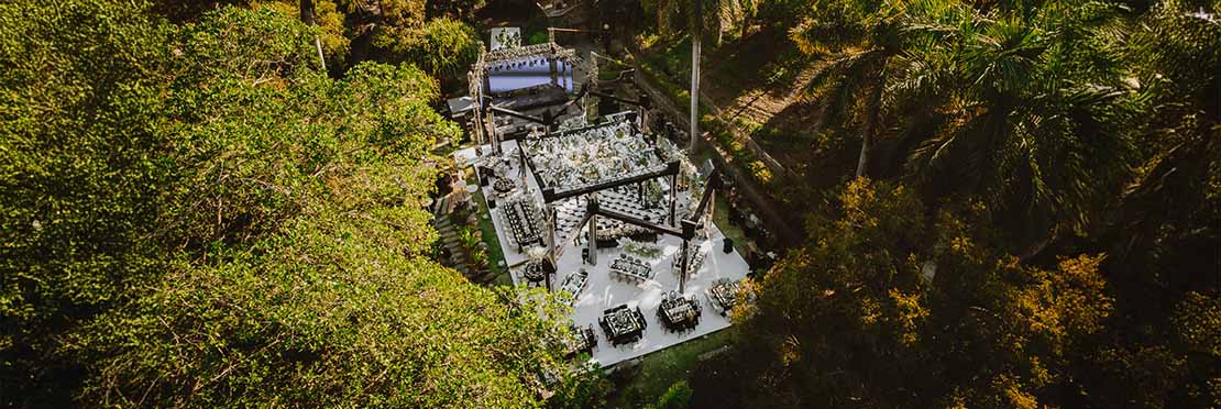 Jardín principal de Quinta Pichón rodeado de arboles con un gran escenario color blanco para un evento.