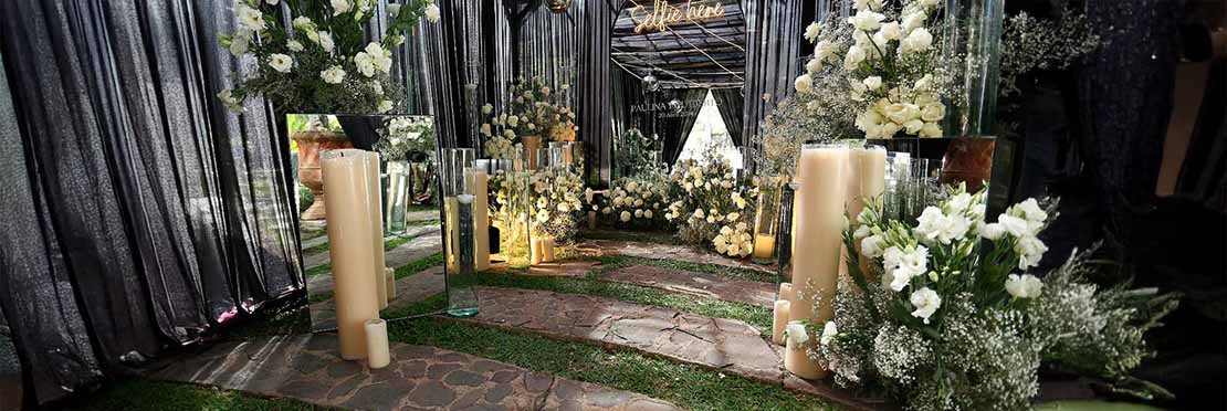 Entrada montada en un jardín de Quinta Pichón para un evento social, este evento es una boda y la decoración predomina el color blanco y es muy elegante.