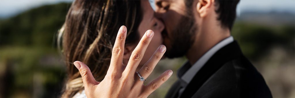 Pareja celebrando si compromiso con la entrega de anillo del novio para la novia.